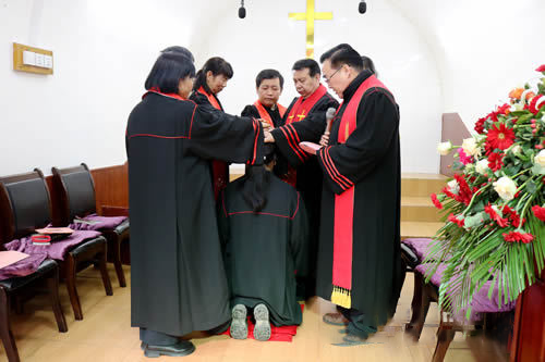 The pastorate put hands on a clergywoman during an ordination ceremony in Wangyi Church, Tongchuan City, Shaanxi Province, on February 18, 2023.