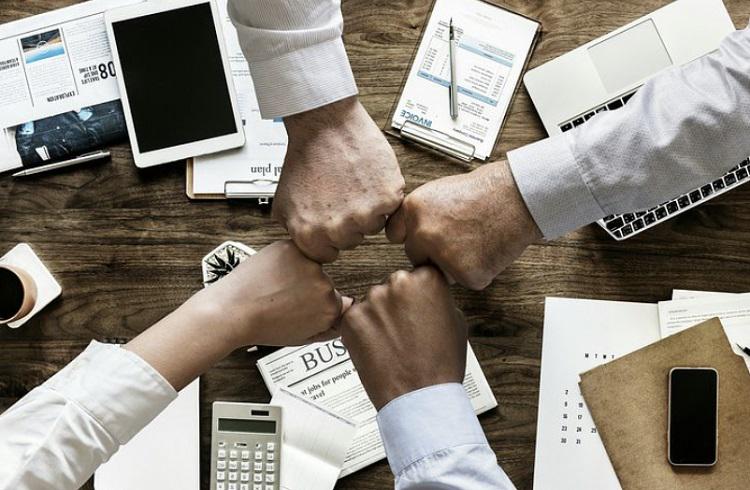 A picture of four fists meeting in workplace