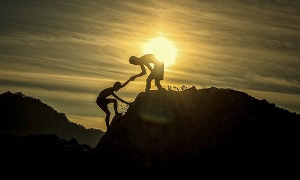 A picture of one man pulling the other up the hill