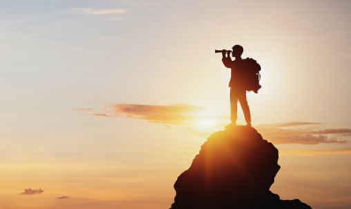 A picture of a man looking into the distance with a telescope on a hill 