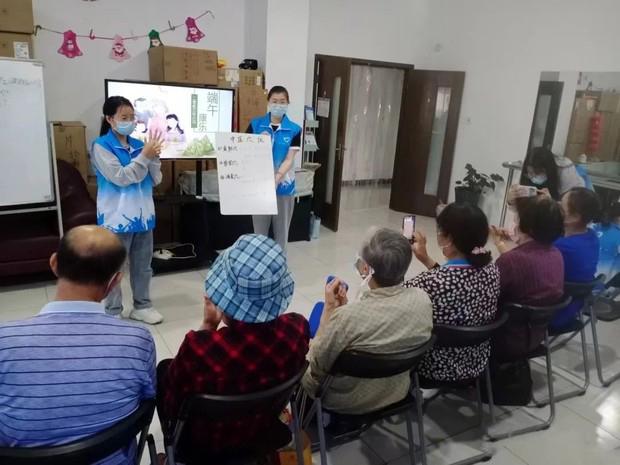 A nursing student from Zhenjiang College in Jiangsu taught the elderly in the community acupuncture points at the Reed's Home Volunteer Service Center on June 2, 2023.