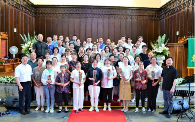 New believers posed for a group photo with flowers in hands at Dushu Lake Church on August 6, 2023.