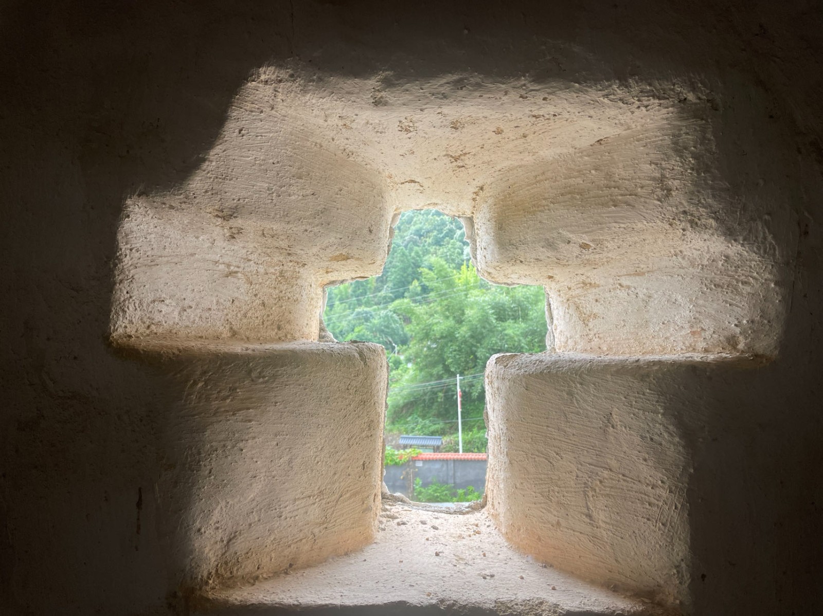 A cross-shaped cutout on a stone wall at a county church of M City