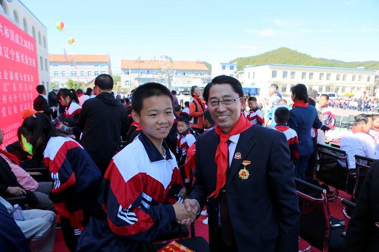 Rev. Ren Chuanyu (right) posed for a photo with a child at a ceremony to donate money to village schools on September 28, 2023.