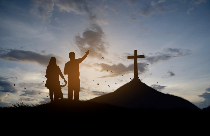 A Christian family stand with cross for worshipping God.