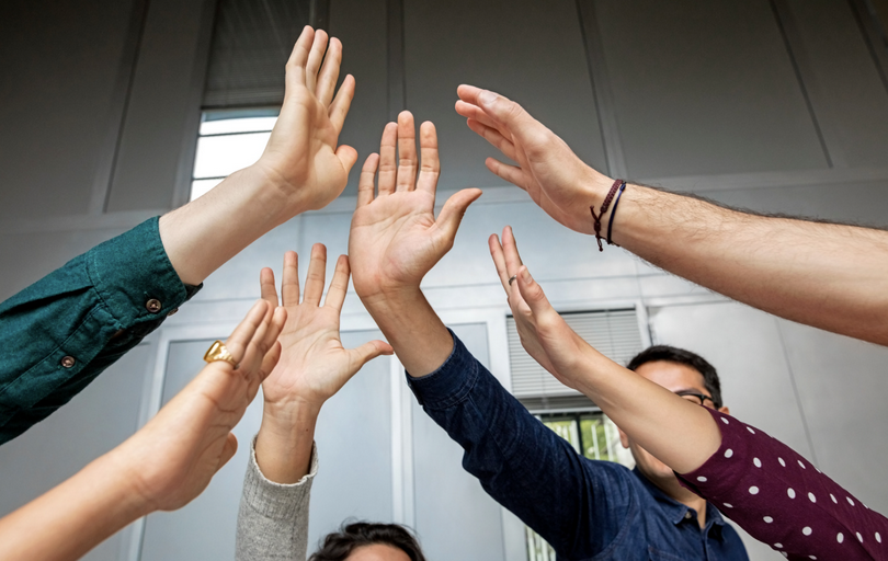 A group of people put their hands together.