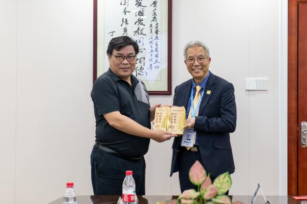 Rev. Fan Hong'en (L), chairman of the Guangdong TSPM, presented a souvenir to Rev. Eric Tong Wing-mun (R), president of the Baptist Convention of Hong Kong, at their meeting in Guangzhou City, Guangdong Province, from November 29 to December 1, 2023.