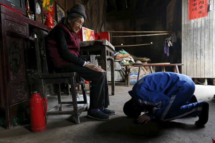 A picture of a young man kneeling and kowtowing before an old woman