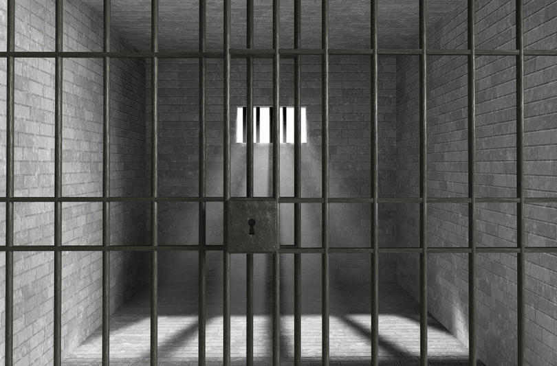 A picture of a prison room with light beams shining in