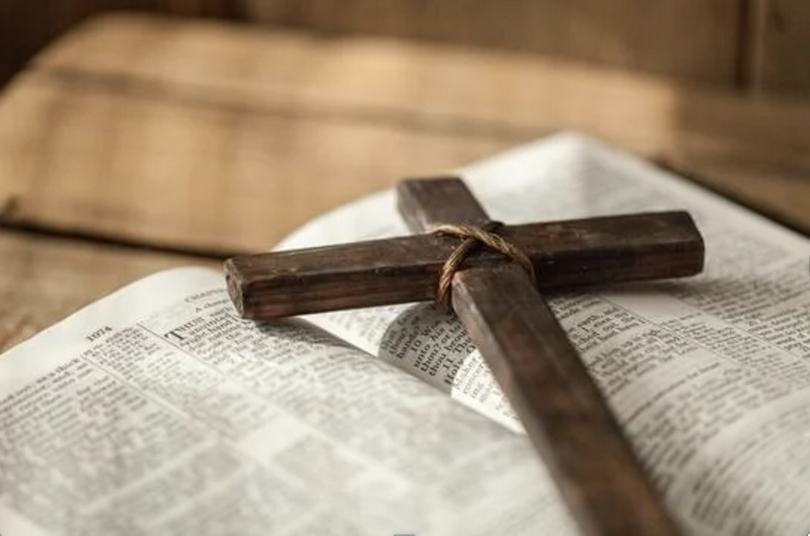 A corss on an open Bible