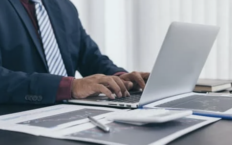 A suited man works in an office.