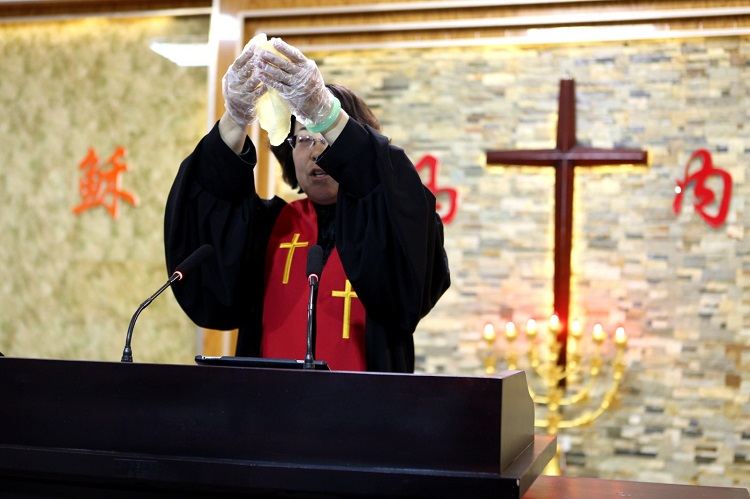 Elder Li Zhuo consecrated the bread during a communion service at Qinghemen District Church, Fuxin, Liaoning, on Maundy Thursday, March 28, 2024.