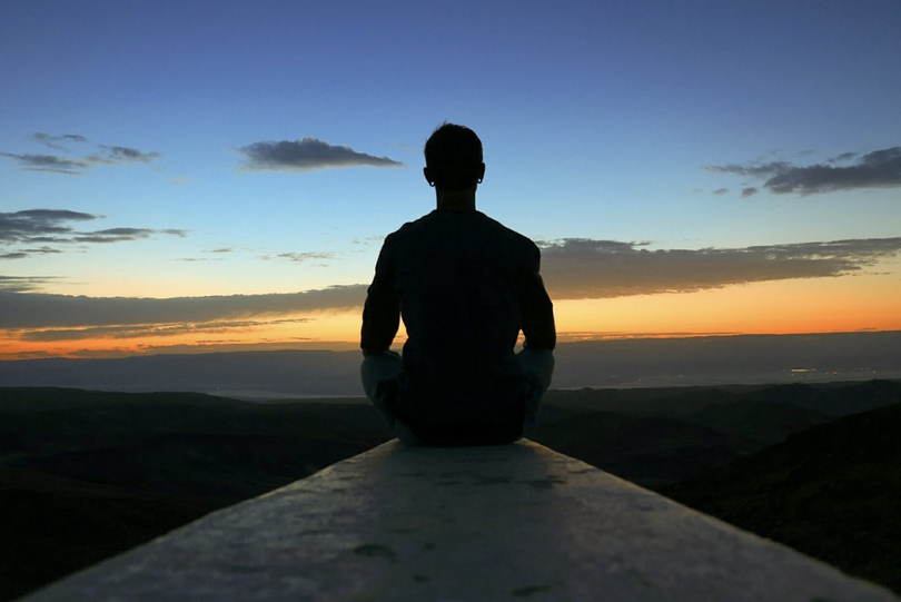 A man on concrete looking at horizon