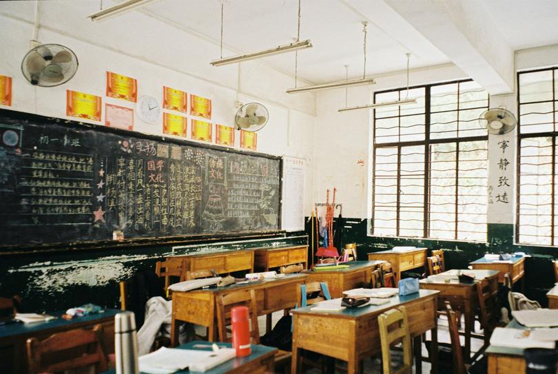 A classroom filled with desks and a chalkboard