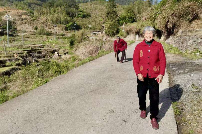 On April 13, 2025, two elderly Christians, dressed in joyful red garments, walked forward with smiles in Chishui Township, Dehua County, Quanzhou City, Fujian Province.