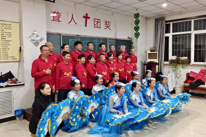 Assistant Pastor Wang Shengjun (first from the left in the front row, wearing red) poses for a photo with deaf members preparing to go on stage on an unknown day in 2024.