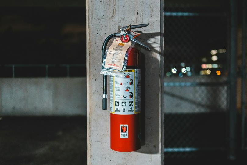 A red fire extinguisher was mounted on a wall.