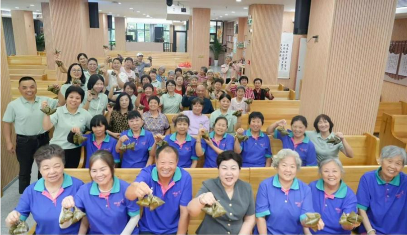 A group photo of the Elderly Cloud Fellowship with rice dumplings in their hands to celebrate the Dragon Boat Festival at Longcheng Church, Longgang District, Shenzhen, on May 28, 2025