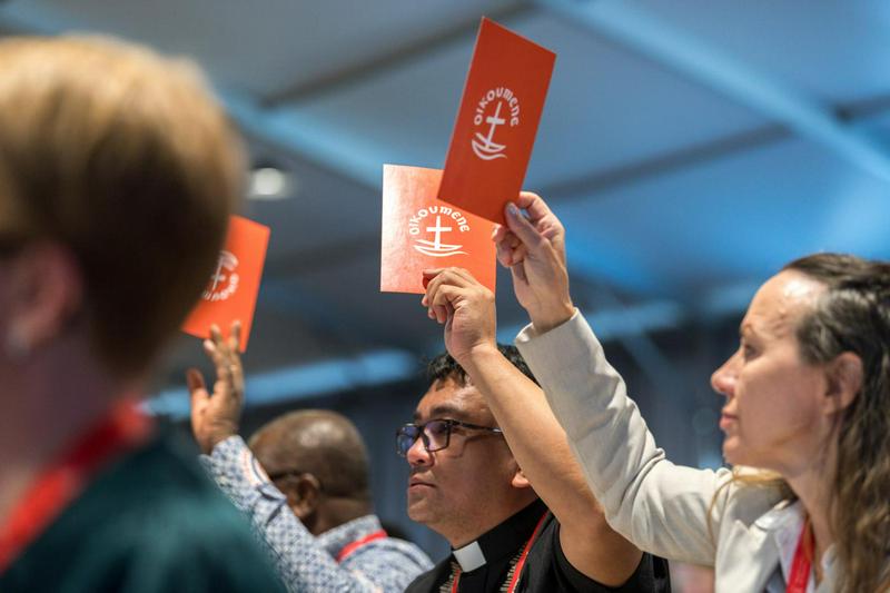 People raise orange consensus cards in affirmation of what has been proposed at the 2025 Central Committee meeting of the World Council of Churches taking place in Johannesburg (South Africa) from 18 to 24 June 2025 on the theme ’Pilgrimage of Justice, Reconciliation, and Unity’.