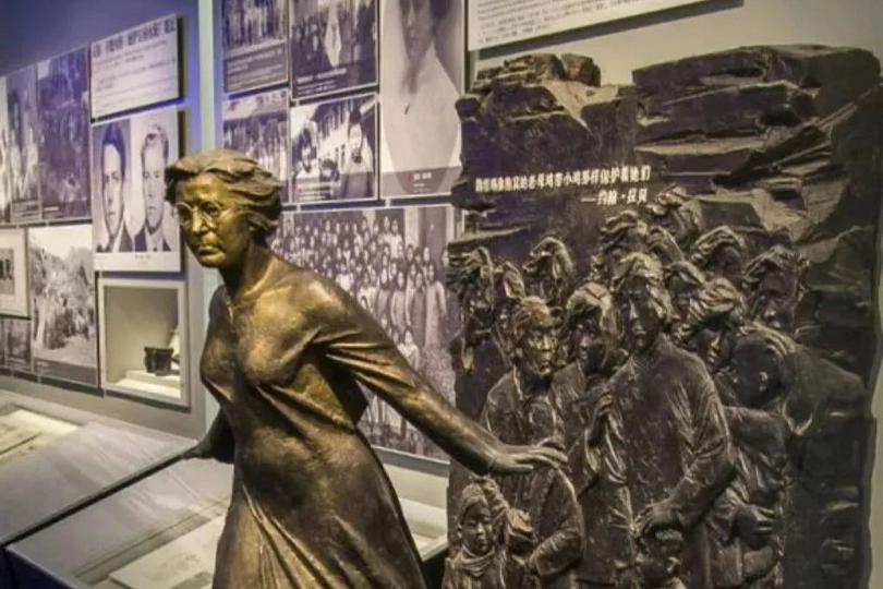 A bronze statue of Minnie Vautrin at the Memorial Hall shows her with outstretched arms shielding Chinese women and children. Above the statue is a quote by John Rabe: “Minnie Vautrin protects them like an old brooding hen protecting chicks!”