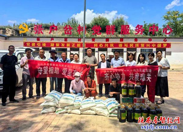 A commemorative photo was taken as the Christian community in Wuqi County sent disaster-relief materials to the affected village recently in Yan'an City, Shaanxi Province.