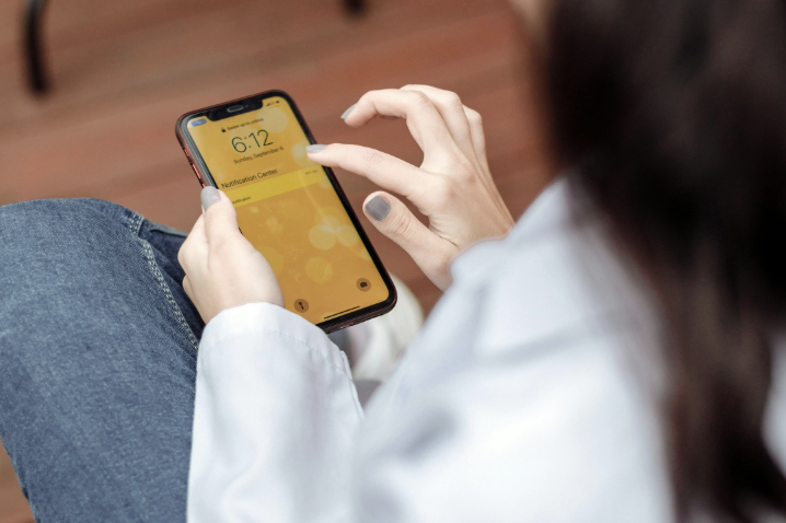 A woman is swiping mobile phone on an unknown day.