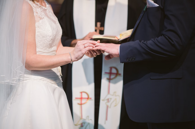 A couple marries with a pastor officiating on an unknown day.