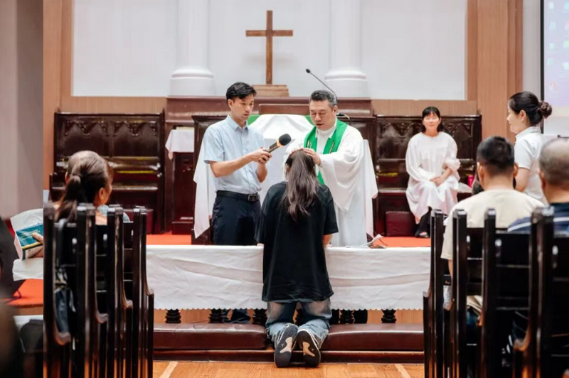 A female participant receives baptism from Senior Pastor Rev. Chen Anfu at Tian’an Church in Fuzhou, Fujian, during the Sunday worship and baptism service on September 14, 2025.