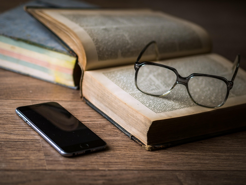 A cellphone, a book, and a pair of glasses