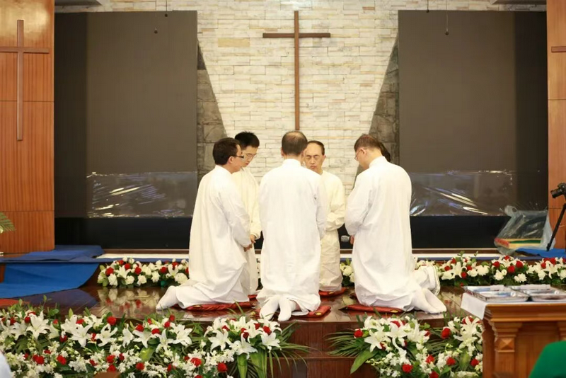 The pastors knelt in prayer for the baptism at Kuanjie Church in Beijing on November 9, 2025.