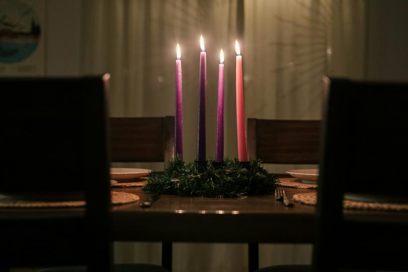 A group of purple candles is placed on a table.