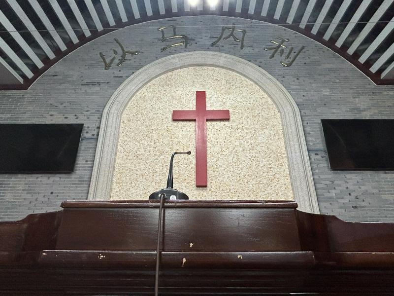 The pulpit and cross inside the chapel of the Dongxinxiang Church in Xi'an, Shaanxi
