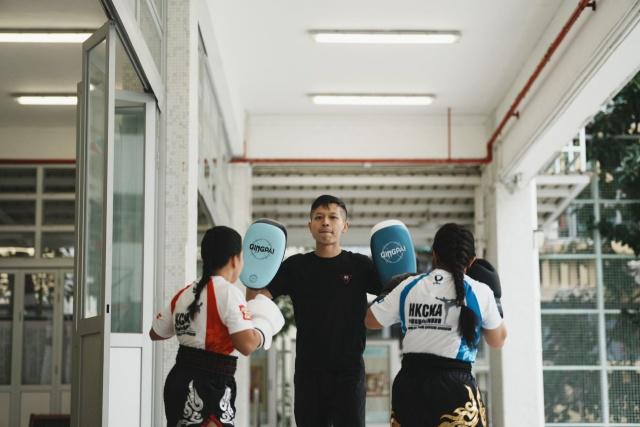 Pastor Ni (center) practices pre-match drills with two Filipino trainees on an unknown day.