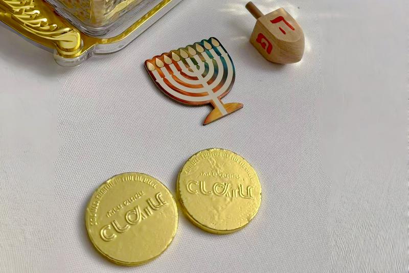 Chocolate coins, spinning tops, and paper menorah placed beside the Hanukkah candles at Ravit Baer's residence in Shanghai, on December 17, 2025