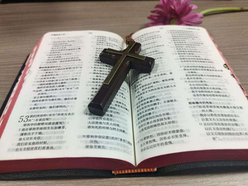An open Chinese Bible with a cross on it