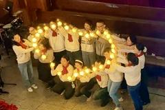 Young believers formed a heart shape while holding candles during a Christmas fellowship event hosted by Huxi Church in Shanghai on the evening of December 19, 2025.