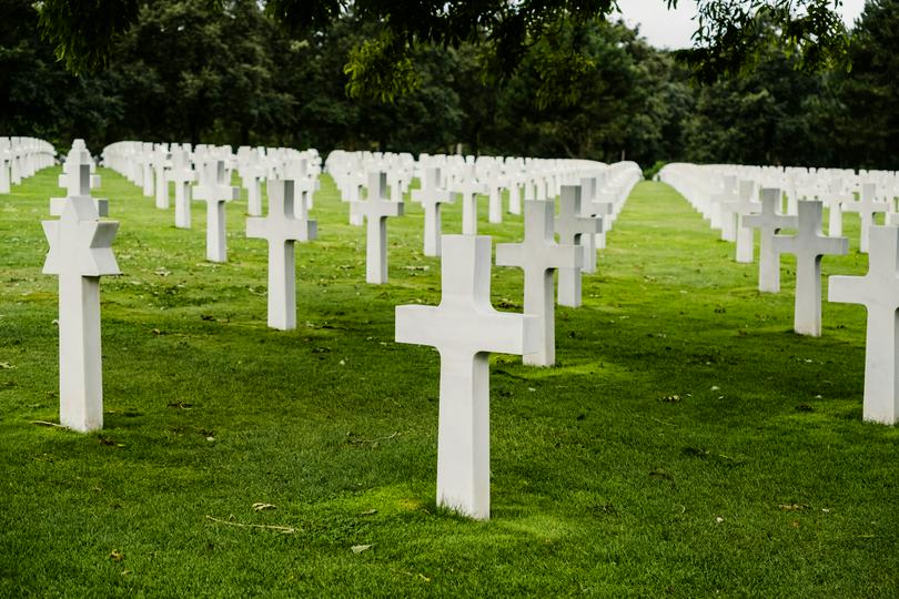 Rows of crosses on the grass of a cemetery