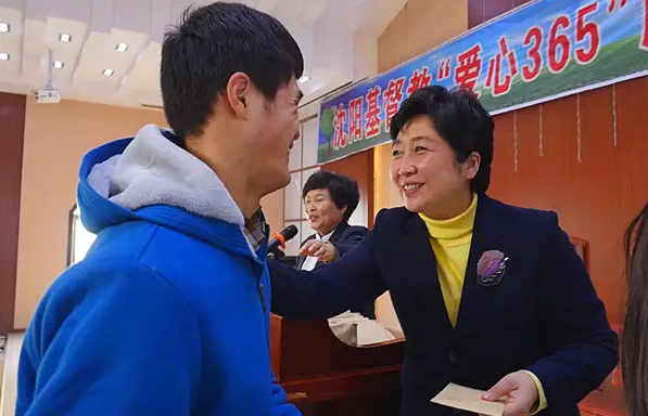 Rev. Wu Mingfeng, president & chairman of Shenyang TSPM & CCC, distributes the money to a family