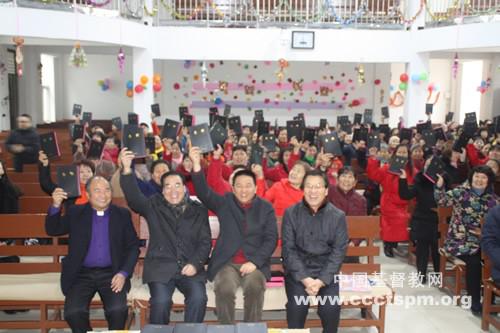 Rev. Shan (Left 3 in the first row) holds the Bible with the congregation in Gujiaxiang Church