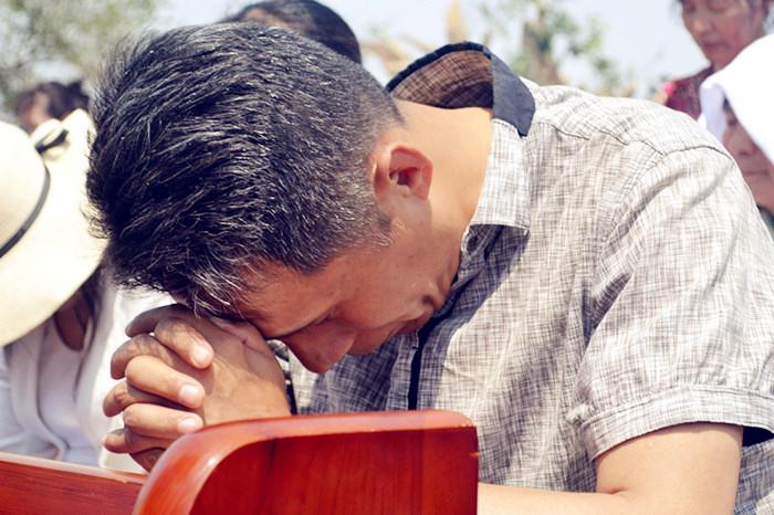 A man prays to God in a gathering