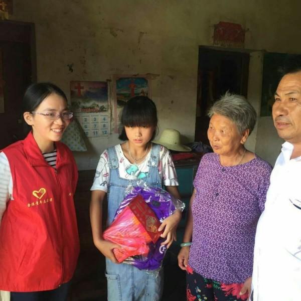 Yu Zhilan (middle) received a fund and a schoolbag from Jin Changjian(right).
