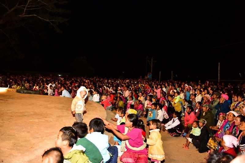Believers watching the dancing, seated in the church yard.