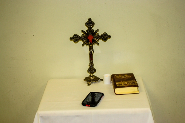 The Bible and a cellphone are placed on a desk.
