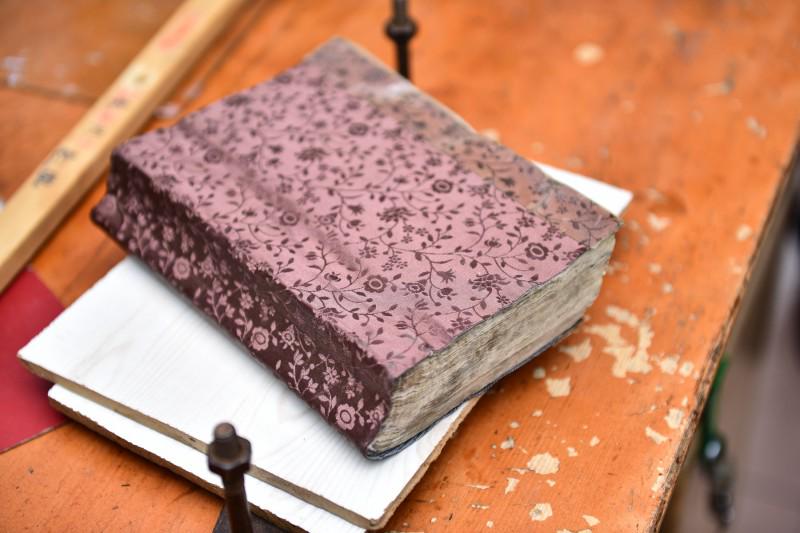 A new cover is attached to an old Bible after Xu's respair.