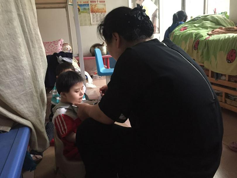 Liu fed a boy in the orphanage.