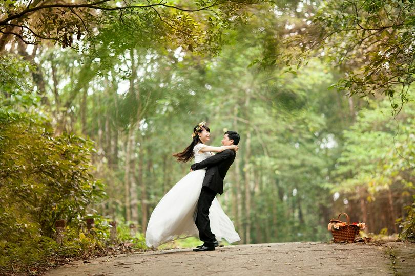 A bridegroom hugs his bride. 
