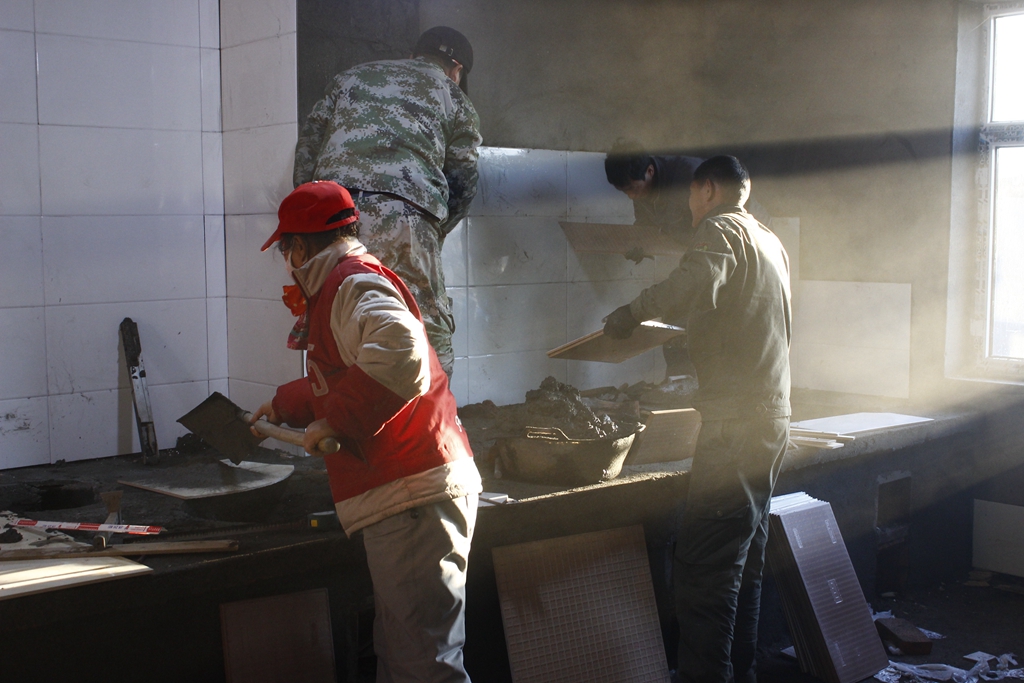 Brothers and sisters stuck ceramic tiles in the kitchen of the side chapel.