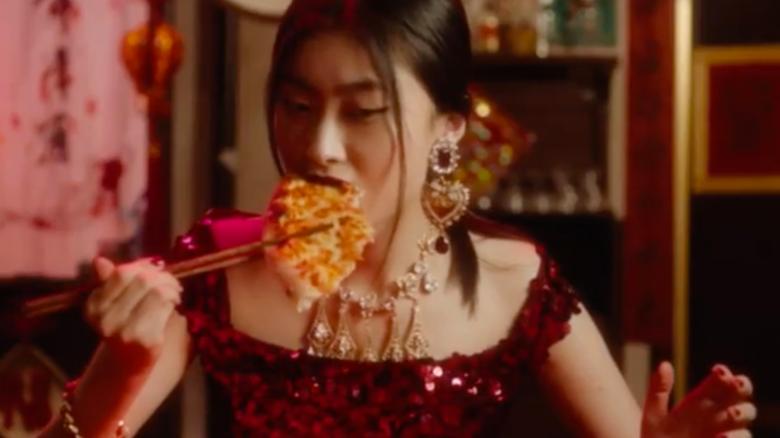 A video ad showing a Chinese woman struggling to eat pizza with chopsticks