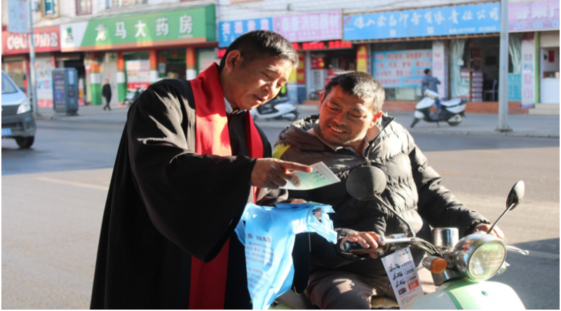 A pastor shows a motorcyclist the AIDS prevention booklet in Baoshan, Yunnan province, on Nov. 30, 2019.