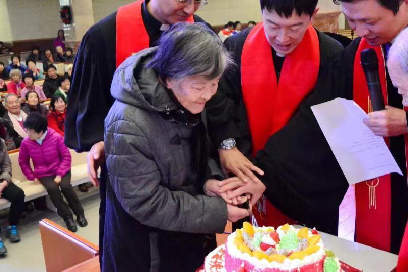 An elderly sister cut the Christmas cake in Dalian Xishan Church on Dec. 21, 2019.